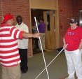 A blind orientation and mobility instructor teaching his student how to use the long white cane.
