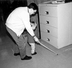 David Small shows his son, Benjamin, how to use the cane to detect obstacles. David finds it helpful to use a positive approach, emphasizing the cane as a helpful tool, while declaring such moments with �aha!� and not �oops.�