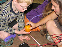 Young boy and girl created a circuit out of a piece of fruit