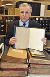 Library Director Morman holding a copy of Louis Braille's 1829 book that first described the Braille code