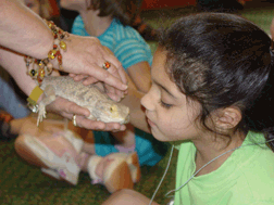 Young blind girl examines a lizard.